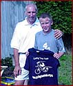 Phil Liggett presents Ben Brodie with a CTT T shirt